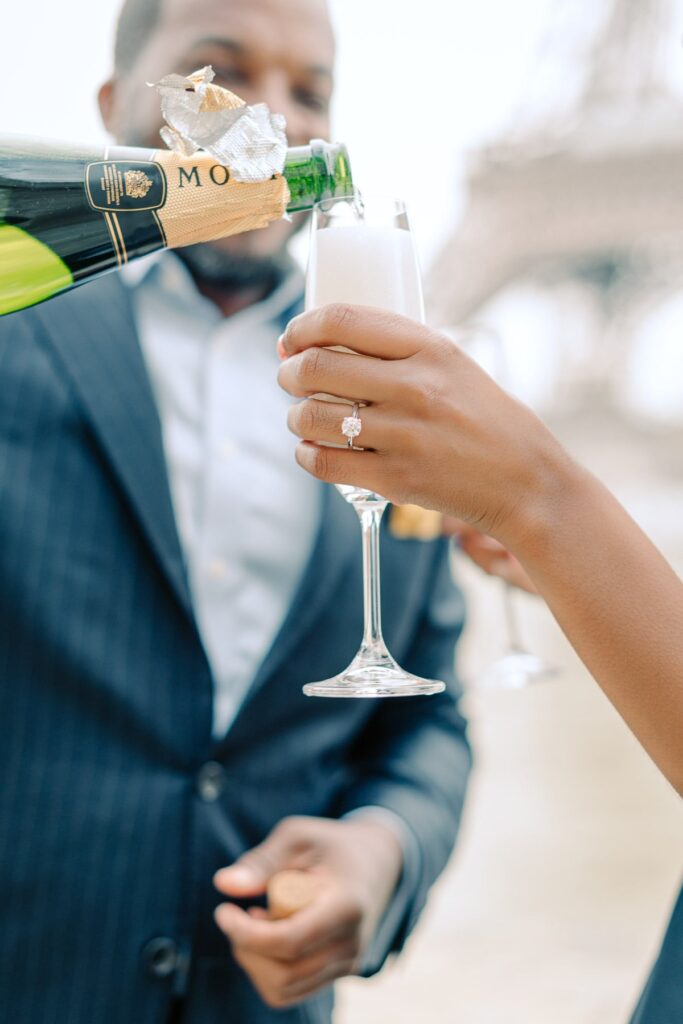 champagne after surprise proposal with engagement ring at the eiffel tower paris